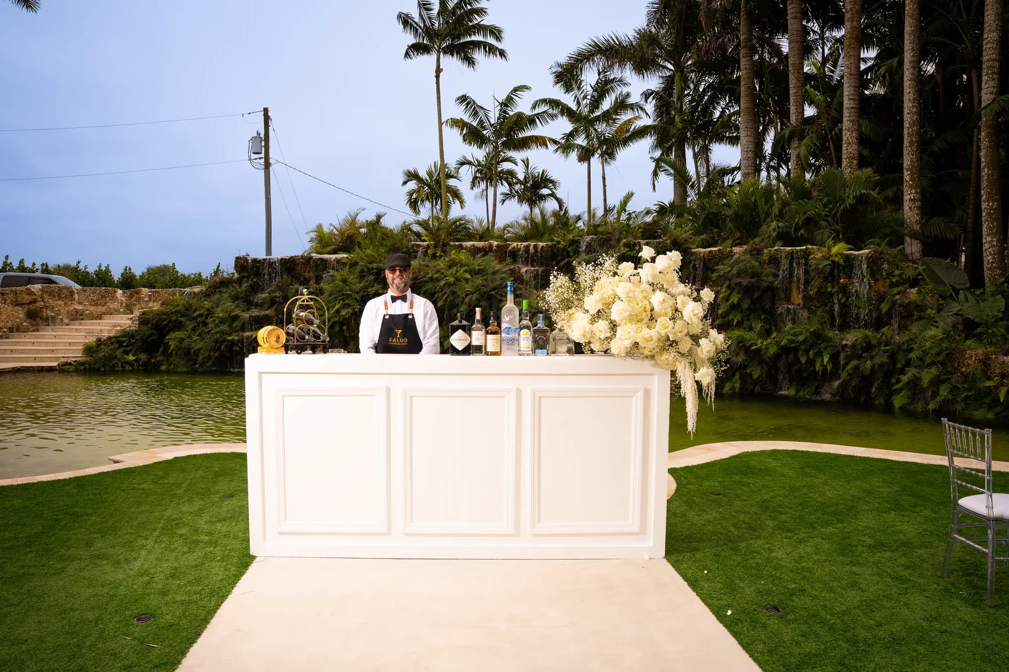 The Salud bar with a bartender ready to serve, set on a garden walkway.